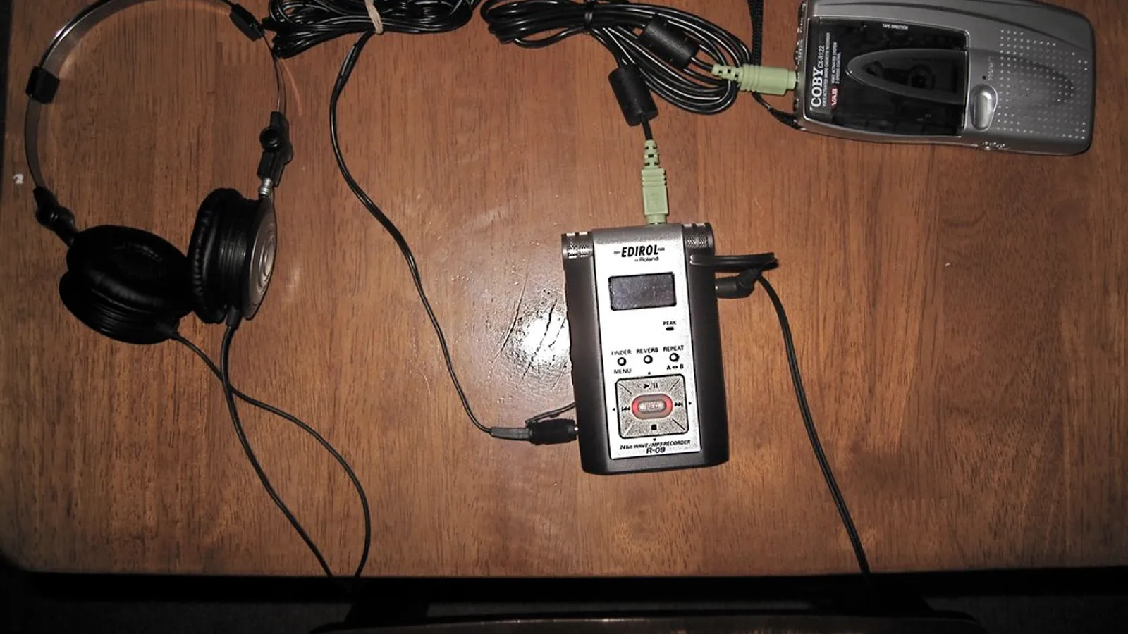 Handheld digital recorder and headphones used to translate Spanish audio to English